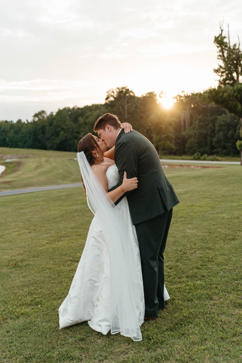 Bride and groom embracing at sunset on their wedding day