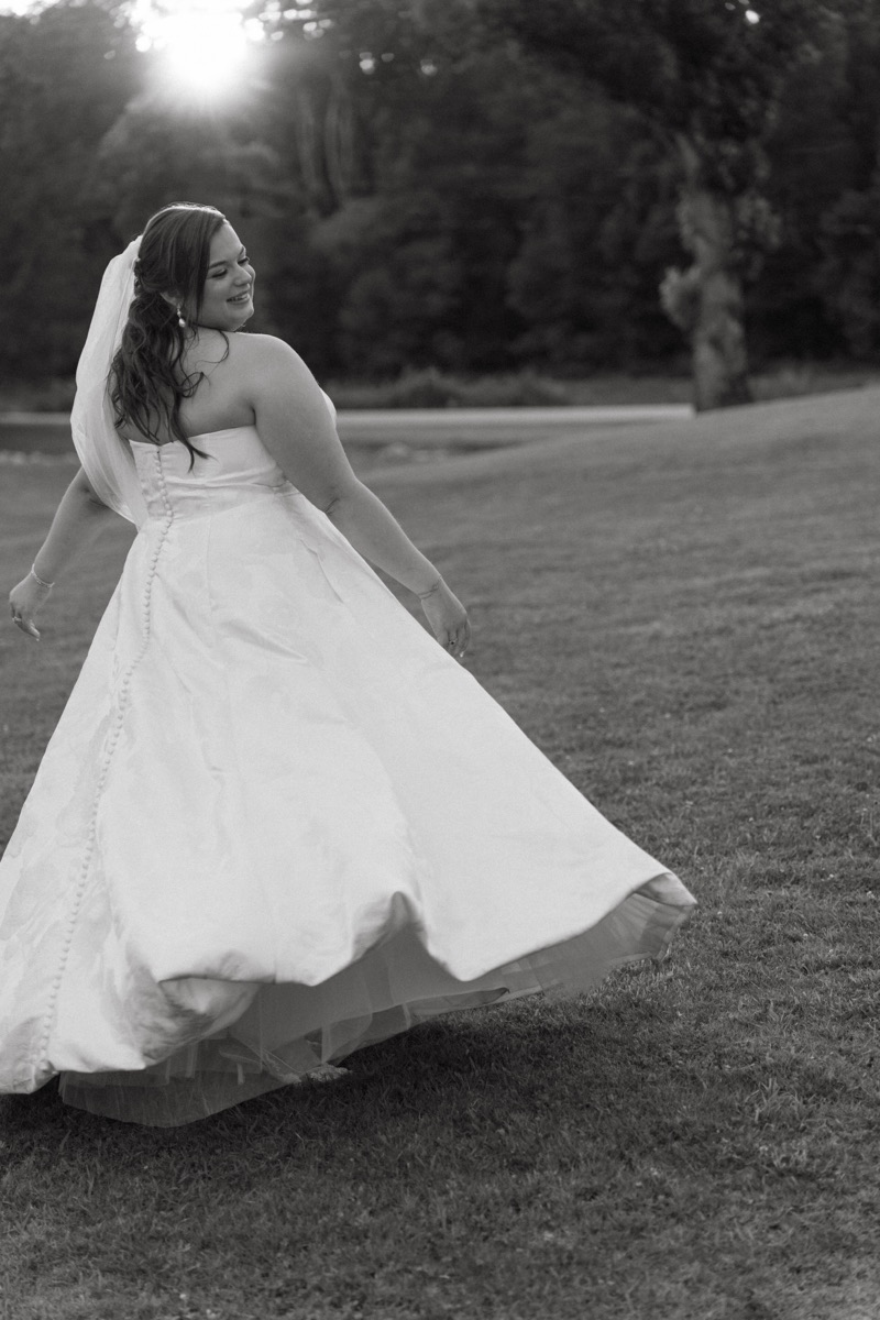 Bride twirling in her gown in a black and white portrait