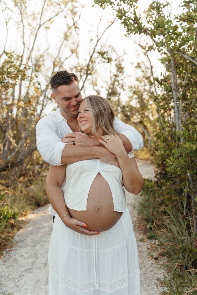 Expecting mother in a white dress during a maternity session